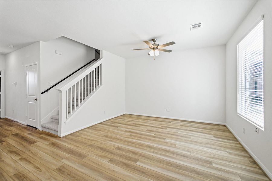 Unfurnished living room featuring ceiling fan and light wood-style flooring Unfurnished living room featuring ceiling fan and light wood-style flooring