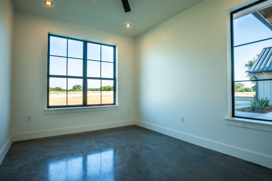 Unfurnished room featuring finished concrete flooring, plenty of natural light, ceiling fan, and recessed lighting