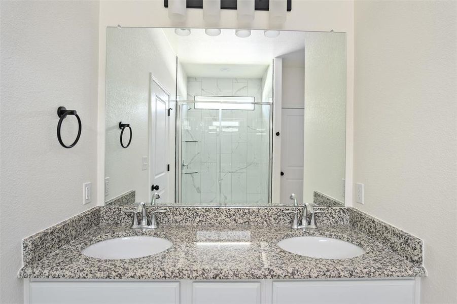 Primary ensuite with a tiled shower and double vanity Primary ensuite with a tiled shower and double vanity