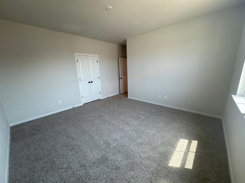 Carpeted spare room featuring baseboards