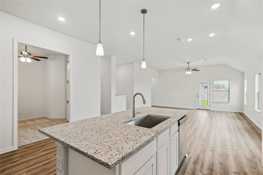 Kitchen featuring an island with sink, sink, and ceiling fan