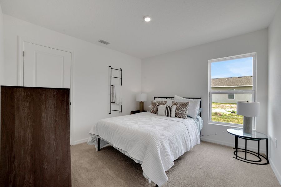 A bedroom with a bed and a table.