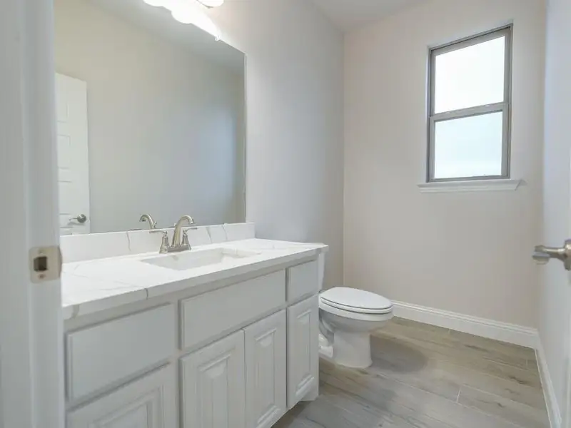 Bathroom featuring wood-type flooring, vanity, and toilet