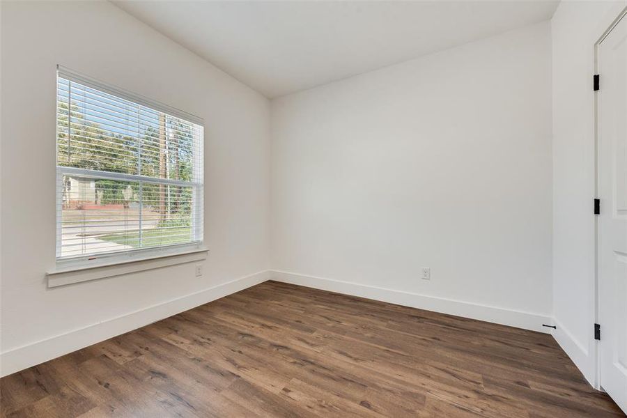 Empty room featuring dark wood finished floors and baseboards Empty room featuring dark wood finished floors and baseboards