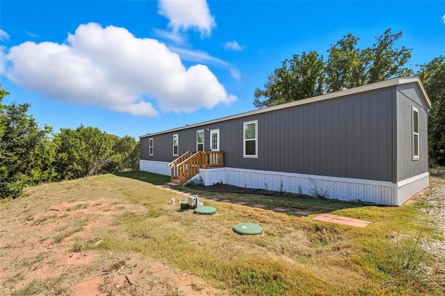 Back of property featuring a yard Back of property featuring a yard