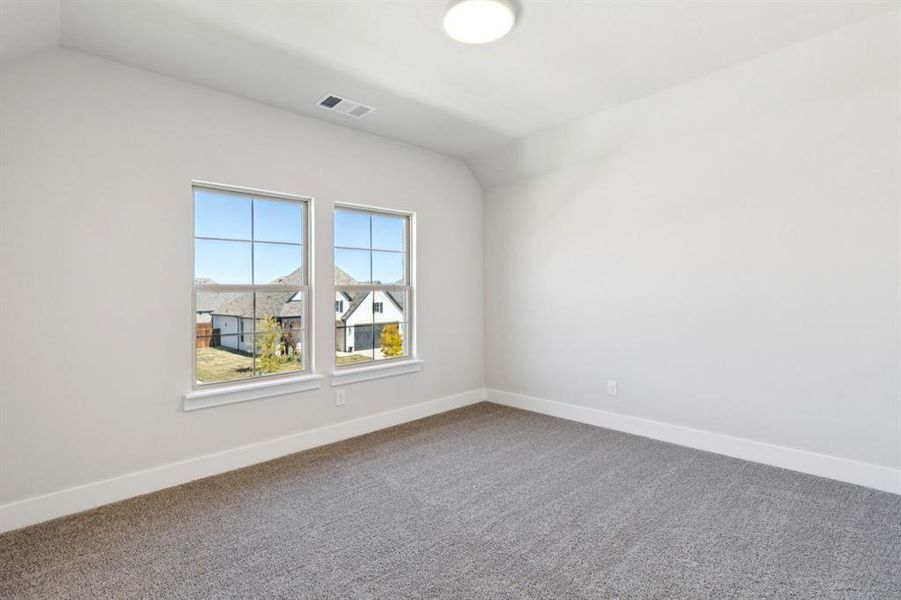 Unfurnished room with carpet floors and lofted ceiling Unfurnished room with carpet floors and lofted ceiling