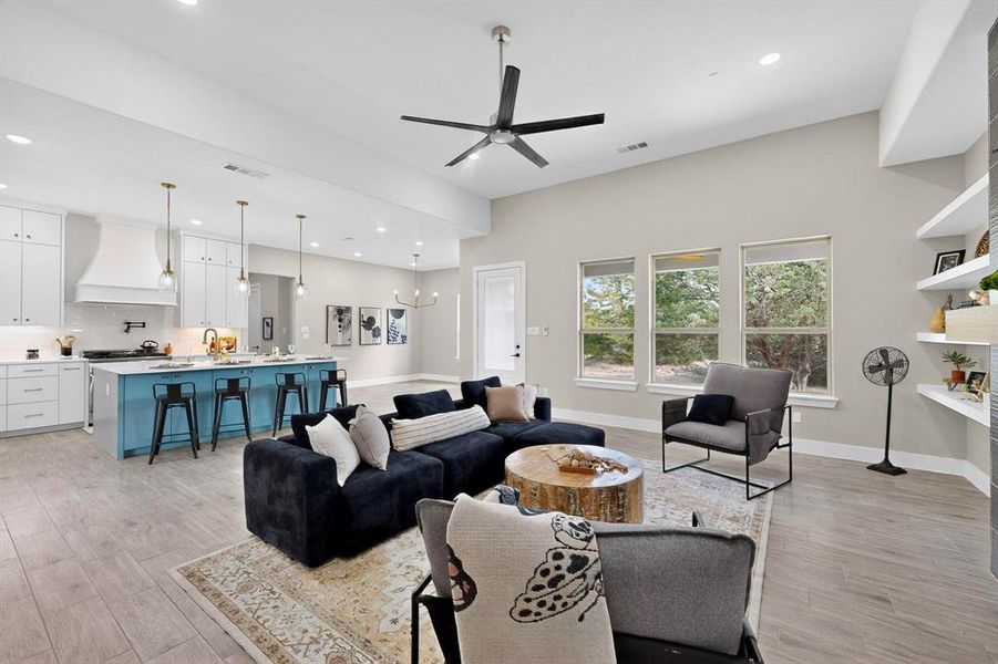 Living area with a chandelier, recessed lighting, light wood-type flooring, and ceiling fan