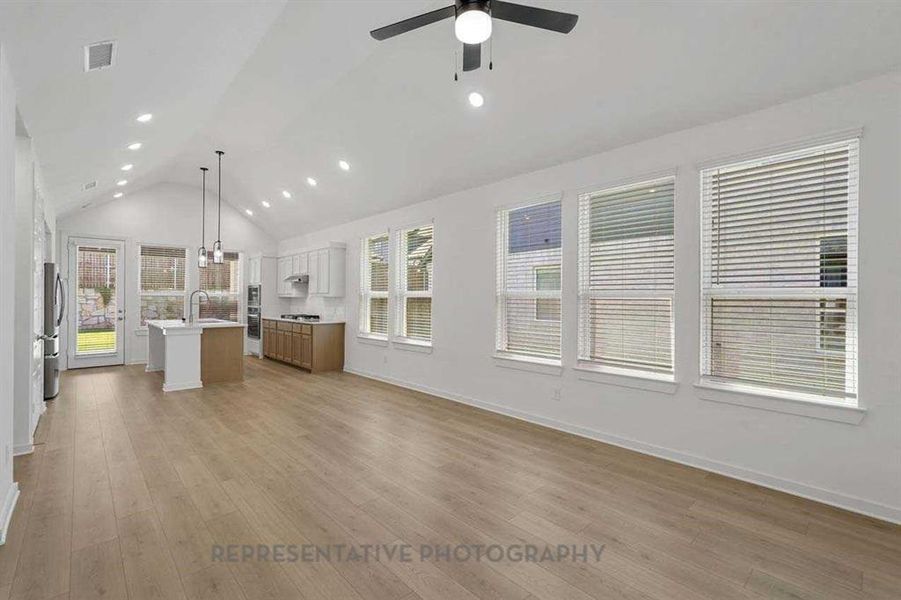 Unfurnished living room with light wood-style flooring, recessed lighting, and high vaulted ceiling