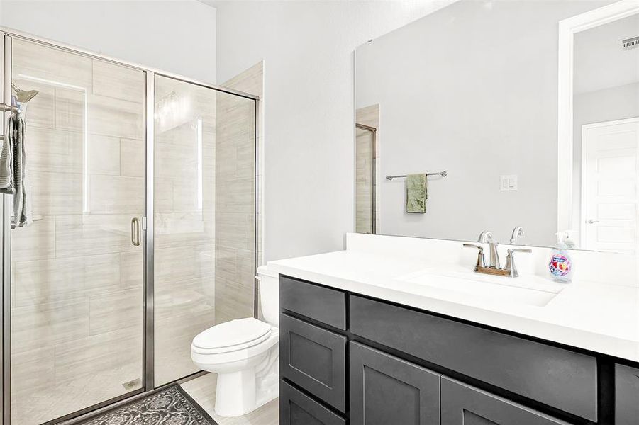 Bathroom with a stall shower and vanity