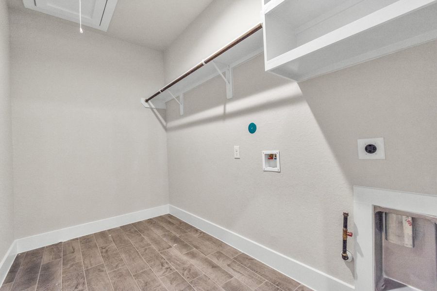 A perfect blend of functionality and comfort. Laundry room, thoughtfully equipped with shelving for effortless organization. Both gas and electric connections available. Sample photo of completed home with similar floor plan. Actual colors and selections may vary. A perfect blend of functionality and comfort. Laundry room, thoughtfully equipped with shelving for effortless organization. Both gas and electric connections available. Sample photo of completed home with similar floor plan. Actual colors and selections may vary.