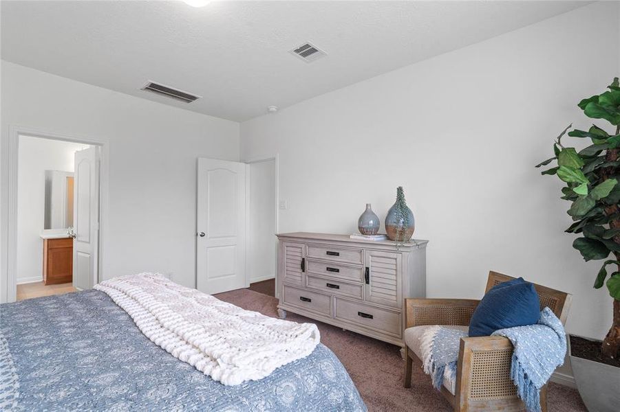 Come and unwind after a long day in this magnificent primary suite! This spacious room features plush carpet, warm paint, high ceilings and large windows with privacy blinds.