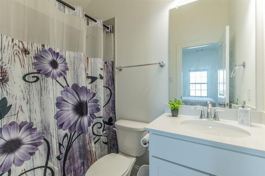 Bathroom featuring a white vanity with an integrated sink, polished chrome faucet, and a large wall-mounted mirror