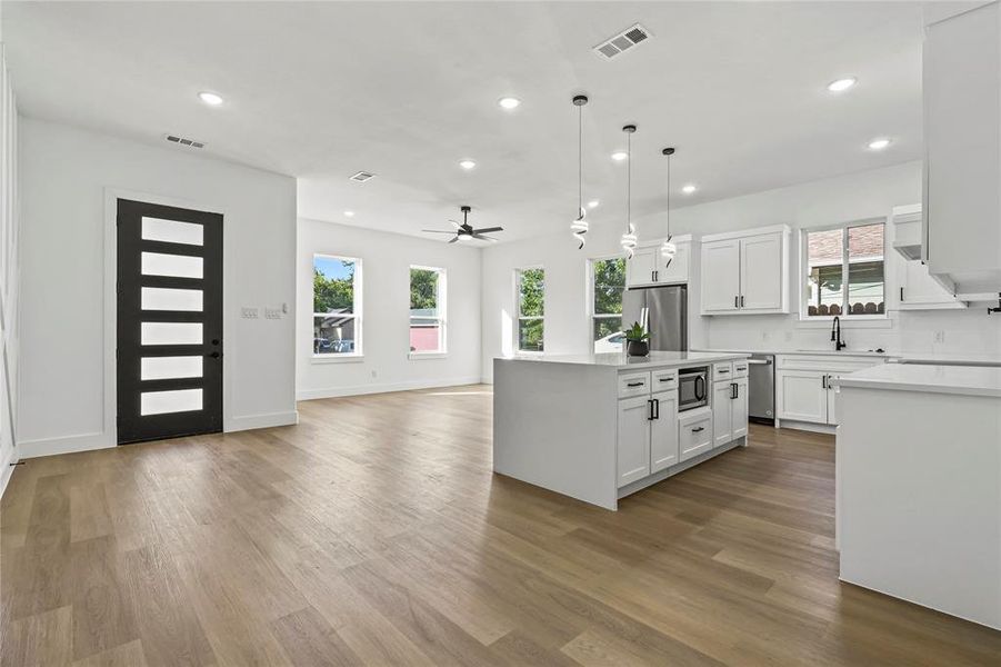 Kitchen featuring light countertops, wood finished floors, white cabinets, ceiling fan, and recessed lighting