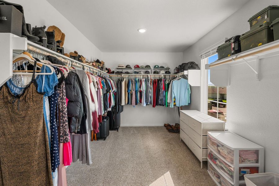 A well-organized primary closet offers abundant hanging space and integrated shelving for all storage needs. A well-organized primary closet offers abundant hanging space and integrated shelving for all storage needs.