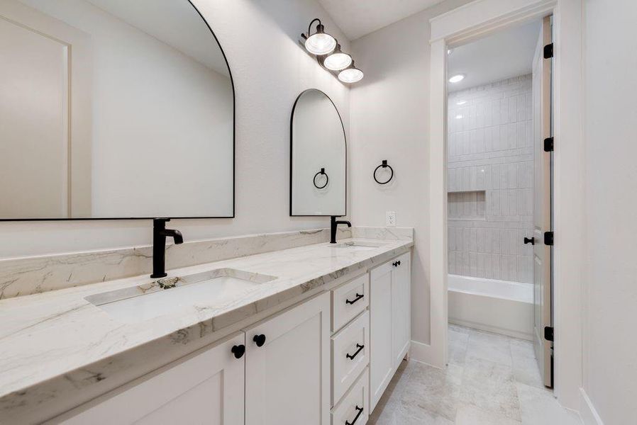 Bathroom featuring vanity and tiled shower / bath