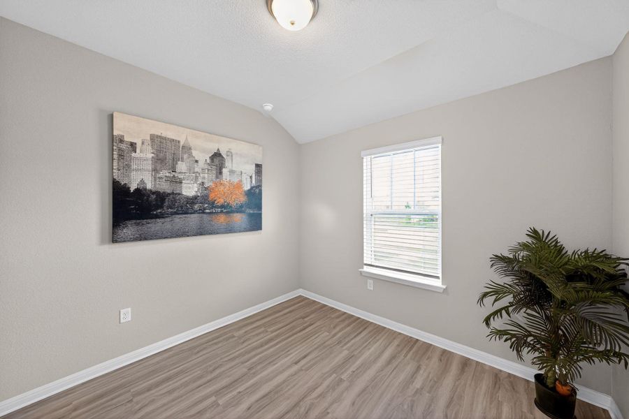 Unfurnished room with lofted ceiling and light wood-type flooring