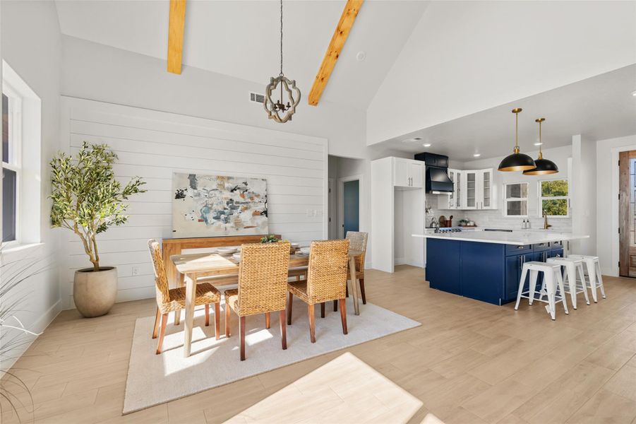 Dining area with high vaulted ceiling, light wood-type flooring, beamed ceiling, and recessed lighting