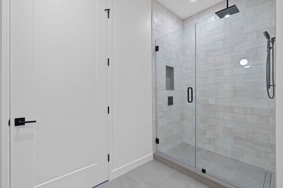 Full bathroom with light tile patterned floors and a stall shower