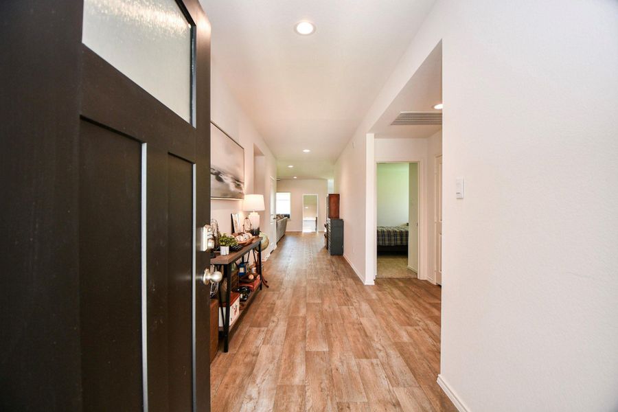 A welcoming entryway with warm, neutral flooring, leading into a bright, open home.