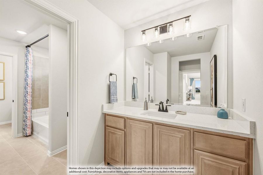 Bathroom with wood vanity, white countertop, large mirror, and separate tub with shower curtain visible through doorway