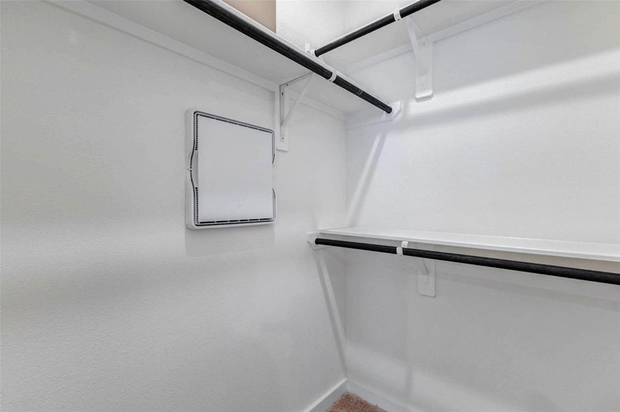 The walk-in closet offers built-in shelving and hanging rods to help keep clothing, shoes, and everyday essentials organized. The clean white walls, upper storage space, and practical layout provide plenty of room to customize the closet for daily convenience and storage needs. The walk-in closet offers built-in shelving and hanging rods to help keep clothing, shoes, and everyday essentials organized. The clean white walls, upper storage space, and practical layout provide plenty of room to customize the closet for daily convenience and storage needs.