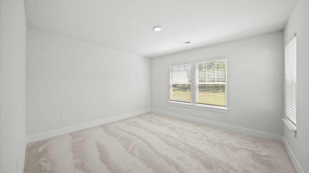 Superior comfort in this light-filled bedroom with plush carpeting and thoughtfully placed large windows