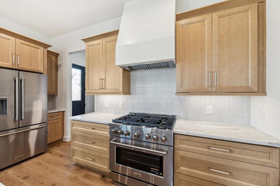 Gorgeous gas oven and stove with exquisite fluted tile backsplash.