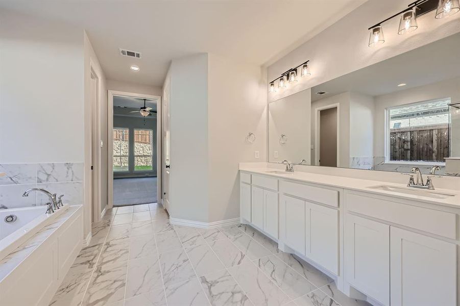 Bathroom featuring vanity, a bathtub, and ceiling fan