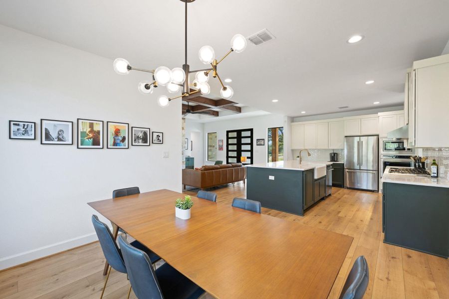 Dining area with light wood finished floors, recessed lighting, a chandelier, and beam ceiling