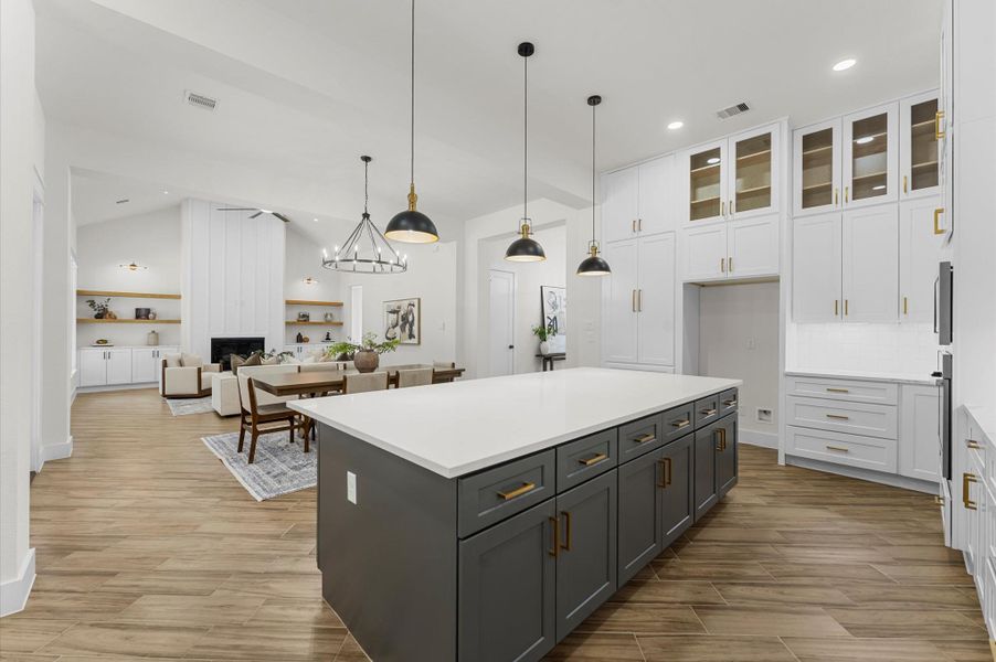 Chef’s dream kitchen featuring custom cabinetry, oversized island, quartz counters, modern fixtures, and abundant windows that overlook the backyard. Chef’s dream kitchen featuring custom cabinetry, oversized island, quartz counters, modern fixtures, and abundant windows that overlook the backyard.