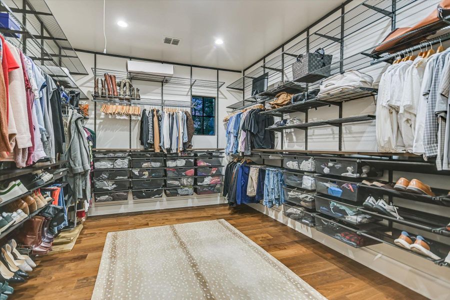 Walk in closet featuring dark wood-style flooring Walk in closet featuring dark wood-style flooring
