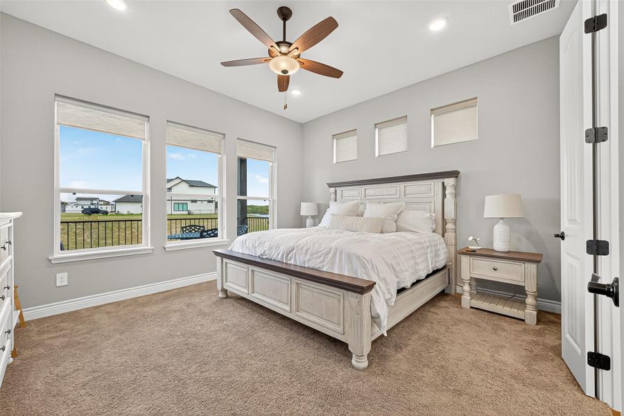 Peaceful primary suite with neutral tones, large windows, and panoramic views of the lake. Features recessed lighting and a ceiling fan for comfort and style. Peaceful primary suite with neutral tones, large windows, and panoramic views of the lake. Features recessed lighting and a ceiling fan for comfort and style.