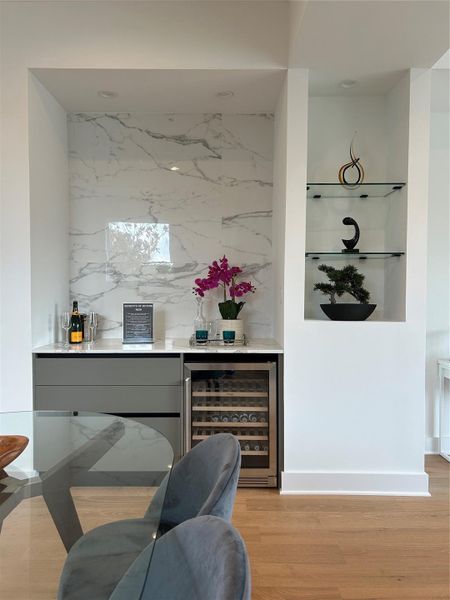 Perfect for entertaining, this elegant dry bar features custom cabinetry, a polished countertop, and a built-in wine fridge for your favorite bottles. Perfect for entertaining, this elegant dry bar features custom cabinetry, a polished countertop, and a built-in wine fridge for your favorite bottles.