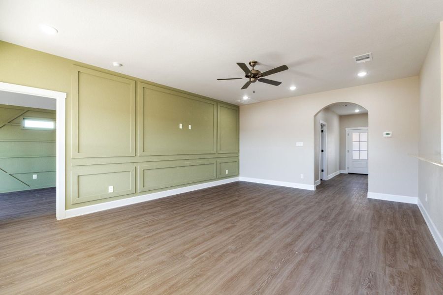 Unfurnished room with arched walkways, ceiling fan, light wood-type flooring, and recessed lighting