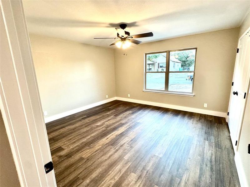 Empty room featuring dark wood finished floors and a ceiling fan