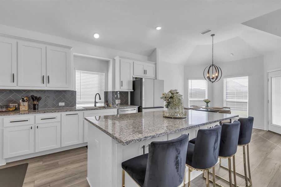 Kitchen with a center island, light hardwood / wood-style flooring, and backsplash