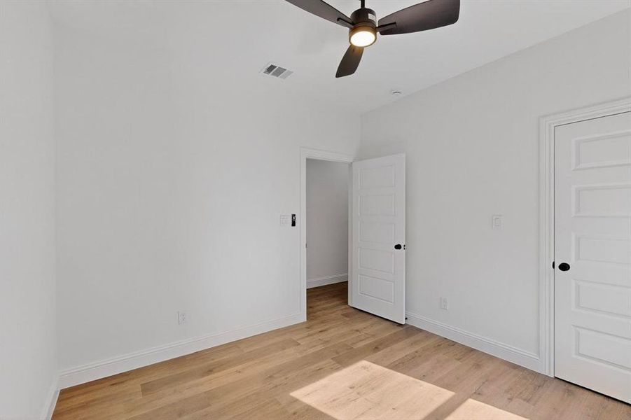 Unfurnished bedroom featuring light wood-style flooring and ceiling fan Unfurnished bedroom featuring light wood-style flooring and ceiling fan