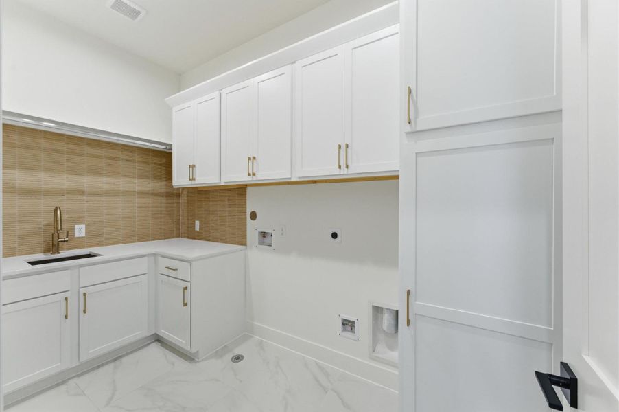 Large laundry room with utility sink.