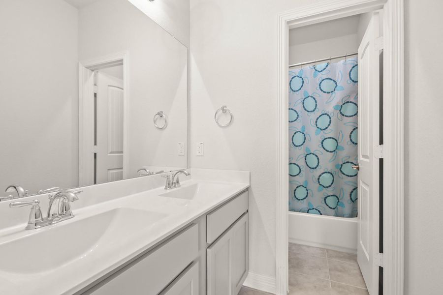 1 of 2 full bathrooms upstairs with separate sinks and closed off shower/toilet combo for smoother morning routines