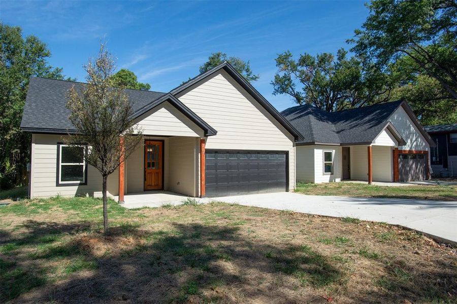 View of front of property with a front yard and a garage