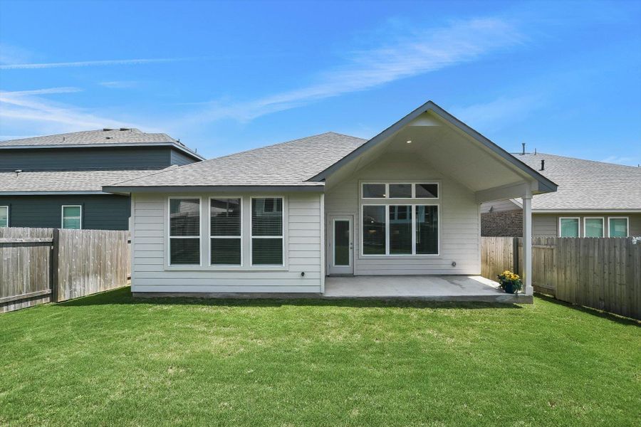 Expansive rear yard featuring a manicured lawn, a covered patio with recessed lighting.  Plenty of space for landscaping or playscape.