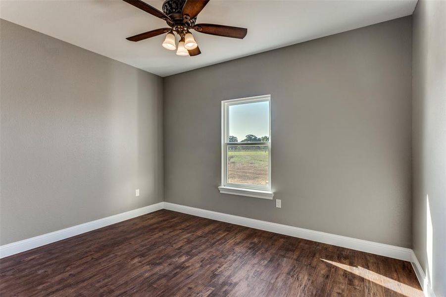 Spare room featuring dark wood-style floors and ceiling fan Spare room featuring dark wood-style floors and ceiling fan