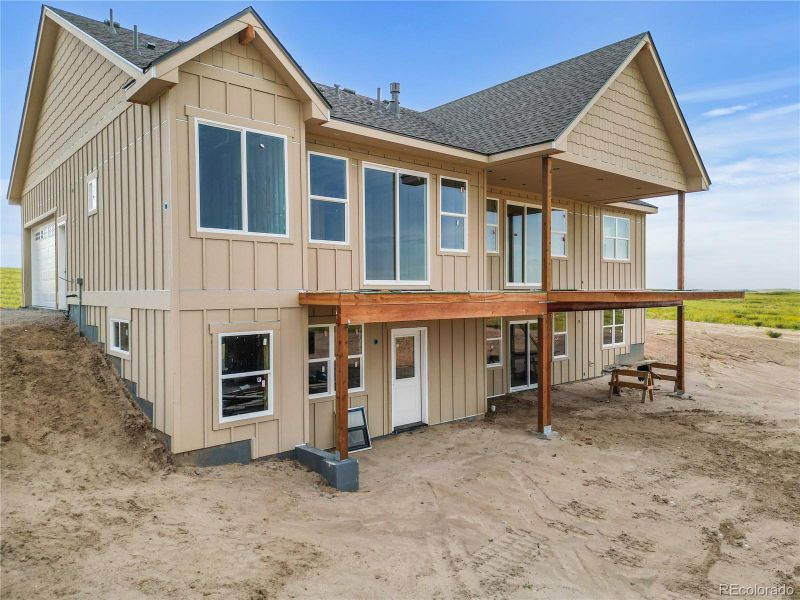 Rear aerial view of the home under construction, showcasing the full walk-out basement structure.