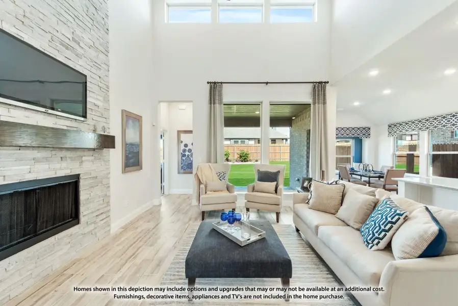 Living room with two-story ceiling, stone fireplace, hardwood floors, and large windows overlooking backyard Living room with two-story ceiling, stone fireplace, hardwood floors, and large windows overlooking backyard