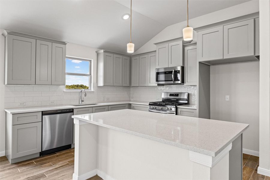 Gleaming stone countertops and shaker cabinetry frame a central island beneath vaulted ceilings. Gleaming stone countertops and shaker cabinetry frame a central island beneath vaulted ceilings.