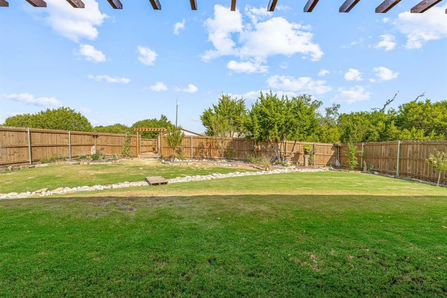 Fenced backyard with a pergola
