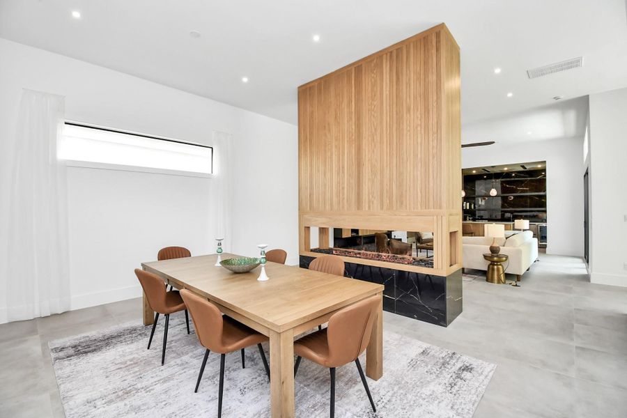 Dining room is separated by a custom built electric fireplace.