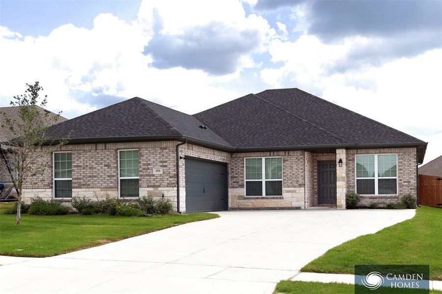 View of front of house with a front yard and a garage