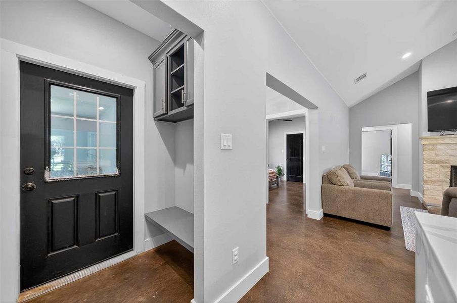 Mudroom with concrete floors, a fireplace, high vaulted ceiling, and recessed lighting Mudroom with concrete floors, a fireplace, high vaulted ceiling, and recessed lighting