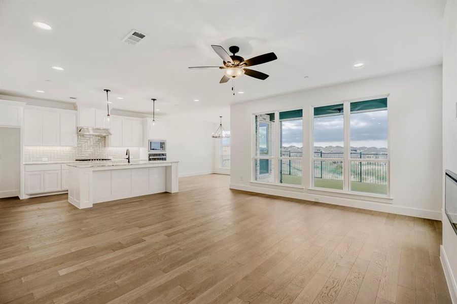 Open-concept living area featuring wood-finish flooring, recessed lighting, and a ceiling fan